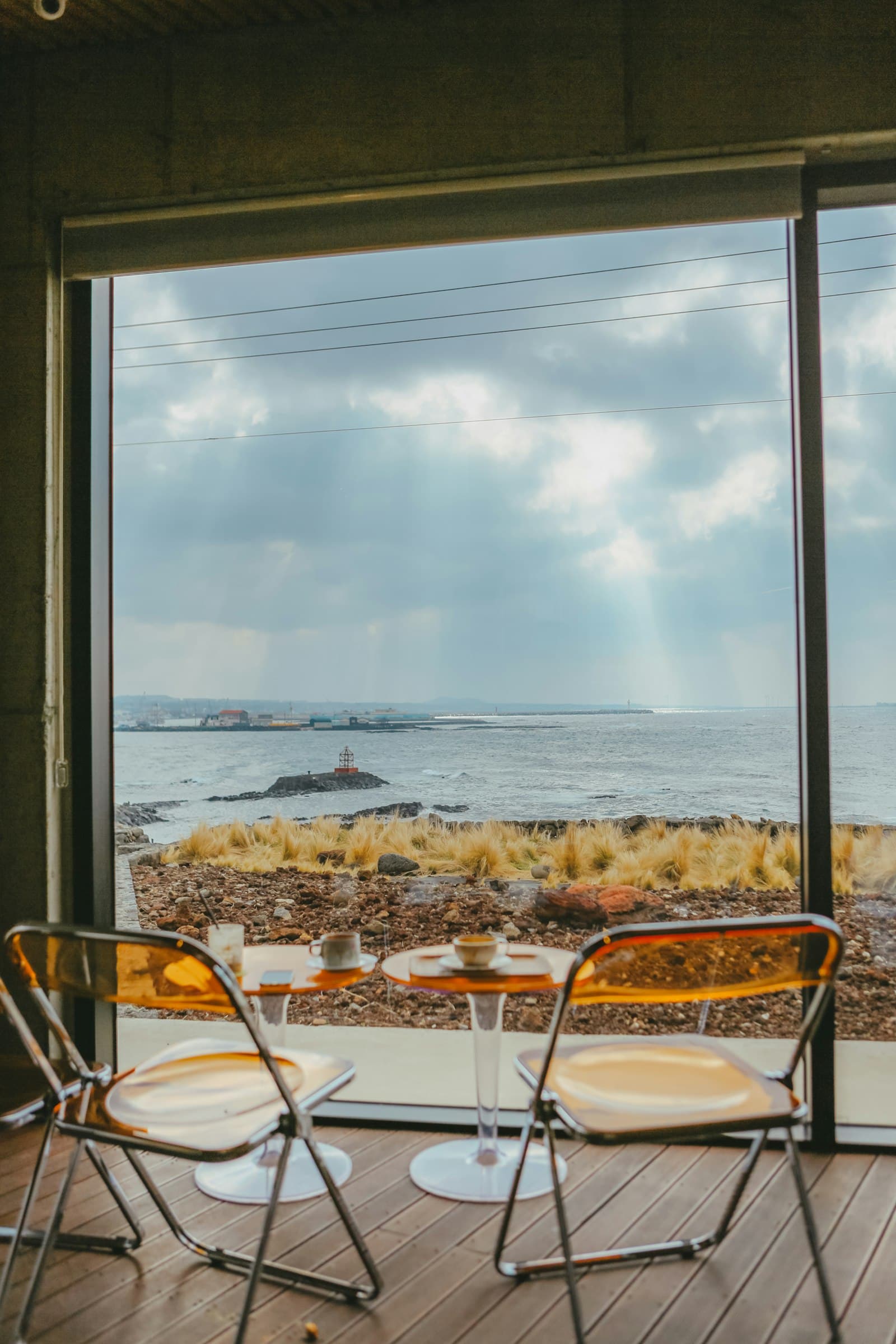 Coastal home interior with two chairs and a window looking out to the ocean