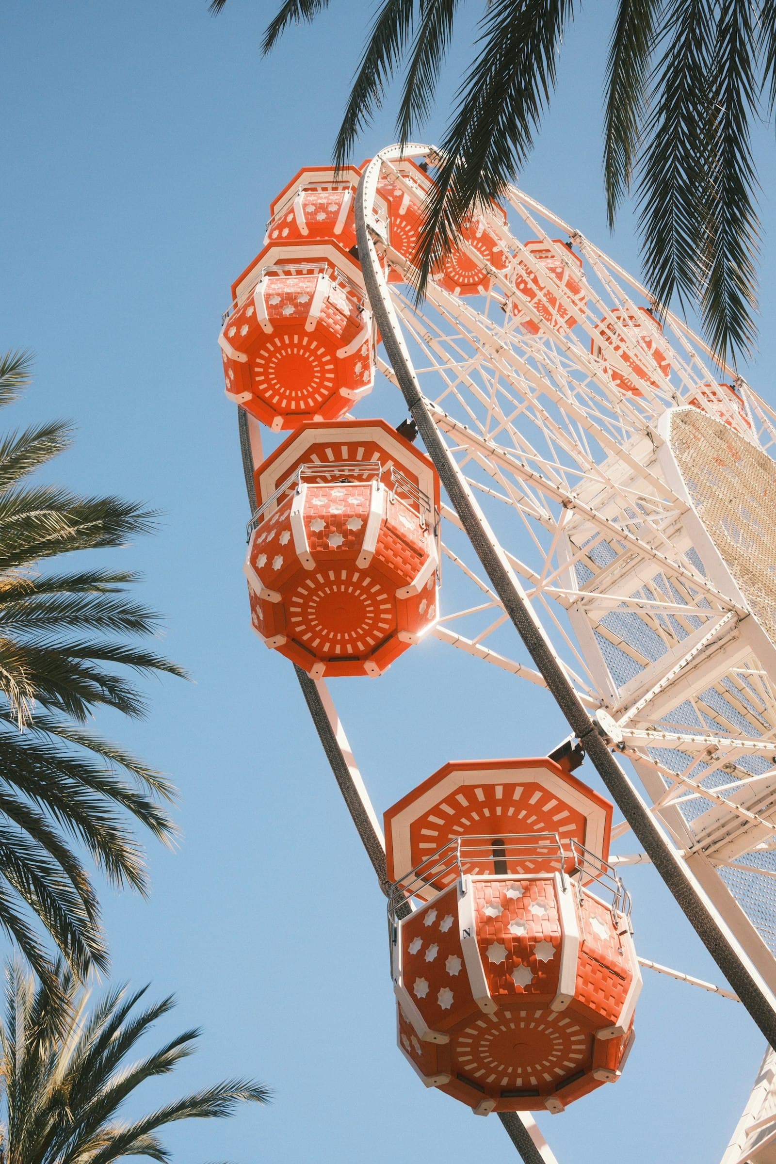 The orange-cabin Ferris wheel at Irvine Spectrum Center rising against a bright blue sky