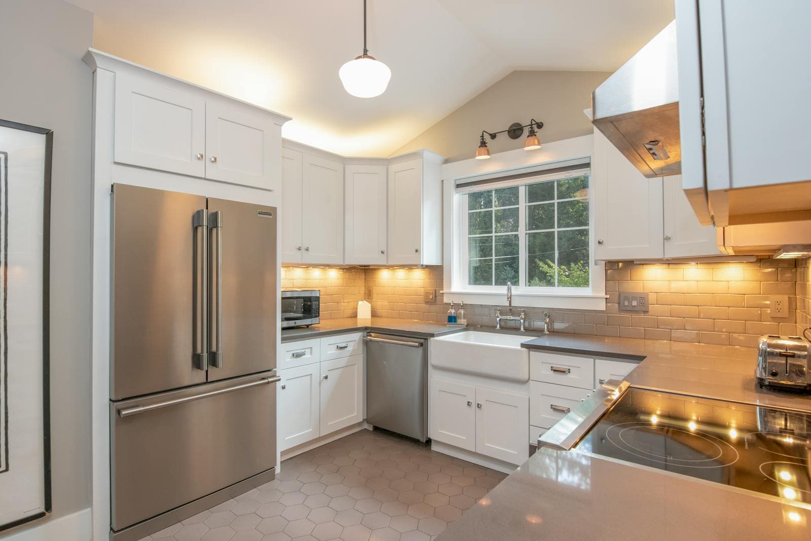 Bright modern kitchen with white cabinets, a central island, and stainless steel appliances