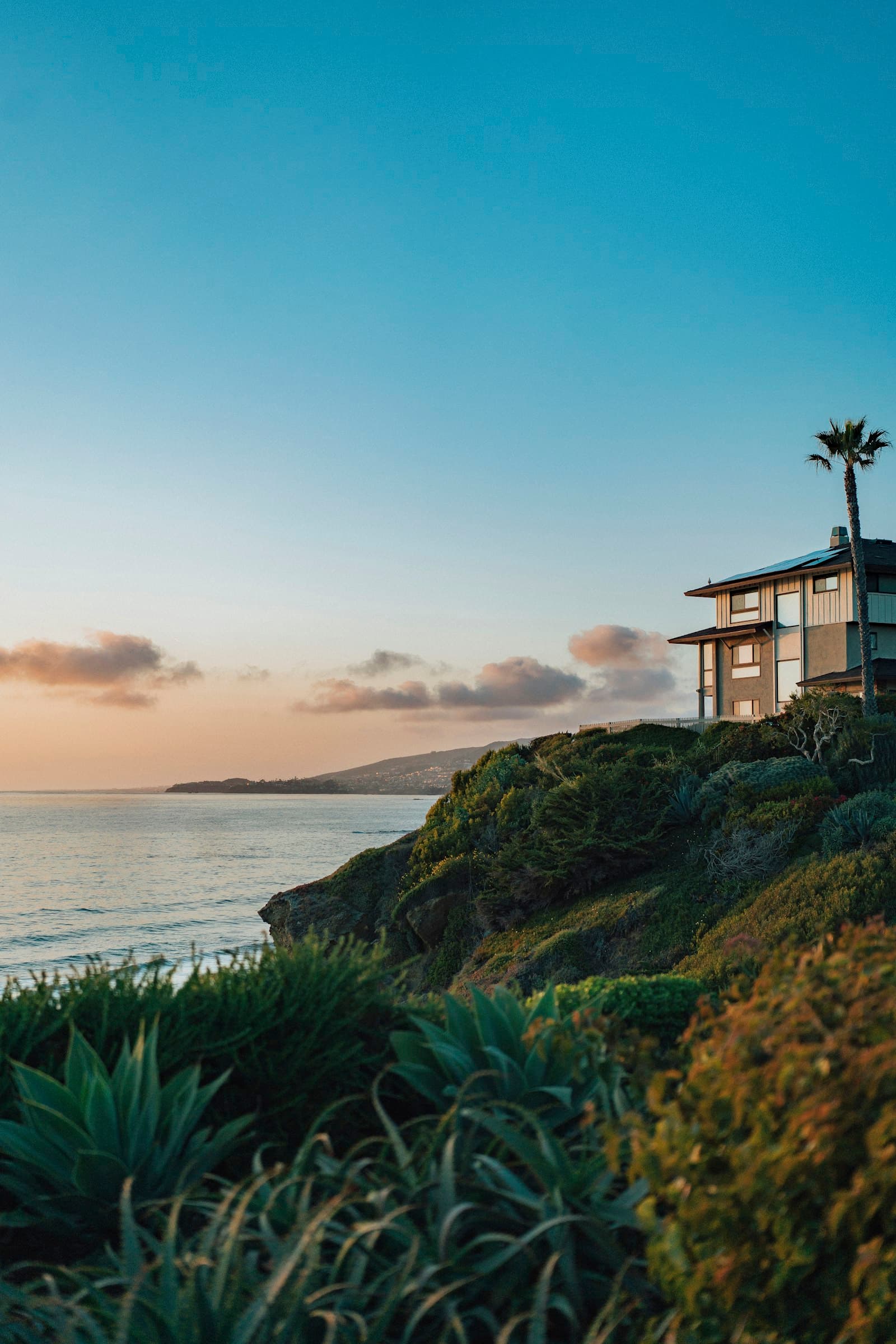 Hillside home with ocean view at dusk along the Southern California coast